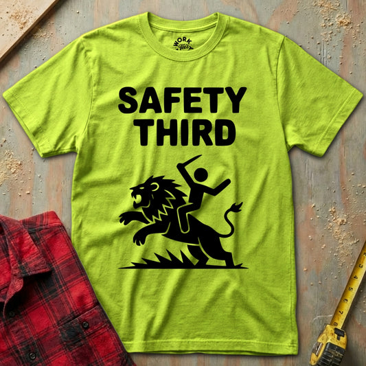 Green t-shirt with 'Safety Third' graphic on a textured surface with a plaid shirt and tape measure.