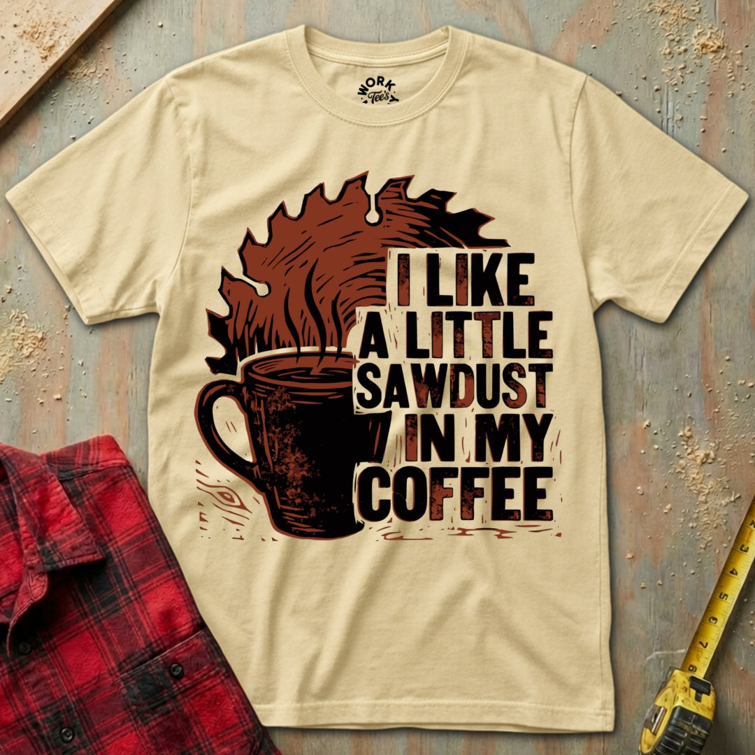 Beige t-shirt with coffee graphic and text on a textured surface with plaid shirt and tape measure.