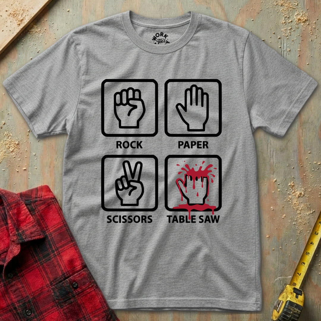 Gray t-shirt with rock-paper-scissors graphic and table saw symbol on a wooden surface.